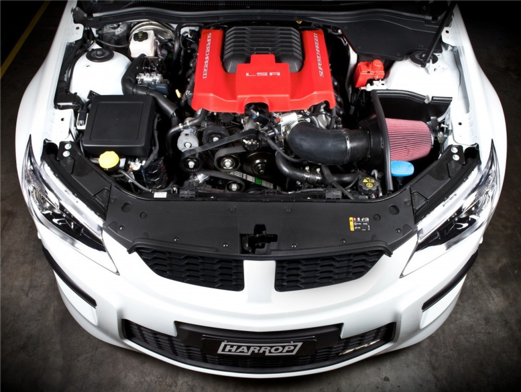 Overhead view of a white car's LSA engine with a red supercharger cover and aftermarket air intake.